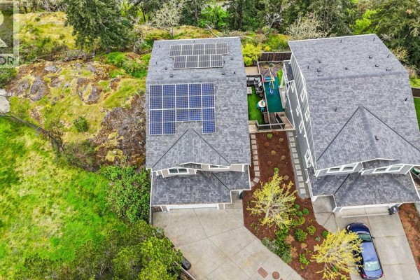 Aerial view of houses with solar panels on roofs and green grassy areas. - 2562 Rosevista Pl, Langford