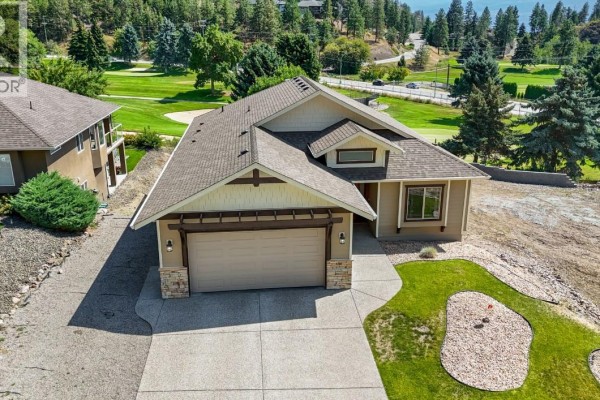 Aerial view of a tan house with a beige garage door, next to a golf course. - 2568 Tuscany Drive Lot# A, West Kelowna