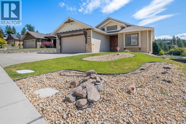 Front view of a tan house with a rock garden in the foreground. - 2568 Tuscany Drive Lot# A, West Kelowna
