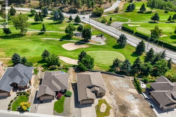 Aerial view showing houses and a golf course with sand traps and green. - 2568 Tuscany Drive Lot# A, West Kelowna