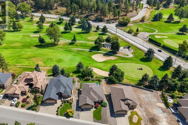 Aerial view of houses and a golf course with cars on a road. - 2568 Tuscany Drive Lot# A, West Kelowna