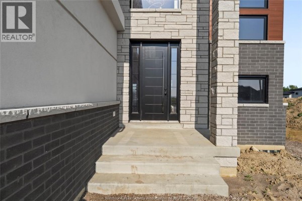 Close-up of the house entrance with a black door and steps leading to the porch. - 2572 Mayfair Avenue South, Lasalle