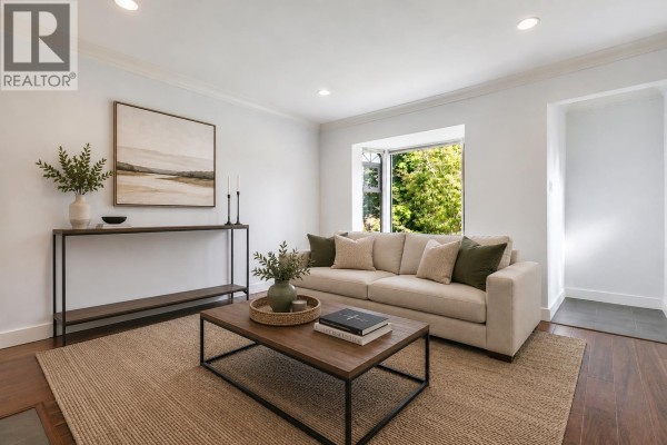 Living room featuring a bay window, sofa, coffee table, and built-in shelving with decorative items. - 2576 Parker Street, Vancouver