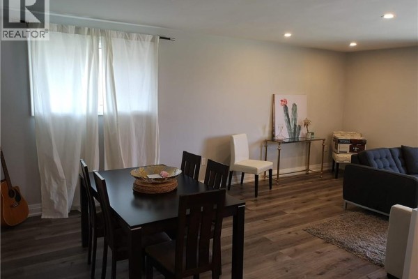 Dining area with a dark wood table and six chairs, next to sheer white curtains. - 258 Carson Drive Unit# Main, Hamilton
