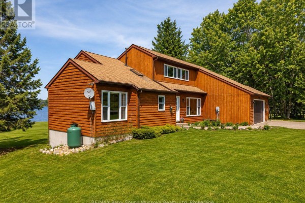 Aerial view of the property and surrounding lakes, showcasing wooded areas and water bodies. - 258 Lakeside Trail, Magnetawan