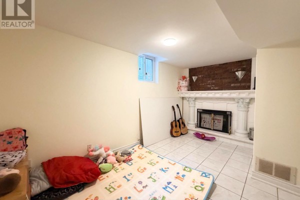 Laundry room with a stacked white washer and dryer, white door, and white tiled floor. - 2587 Credit Valley Road, Mississauga