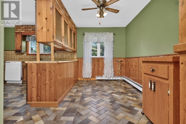 Kitchen with wood cabinetry, green walls, wood wainscoting, and tiled floor. - 2587 Sackville Drive, Upper Sackville