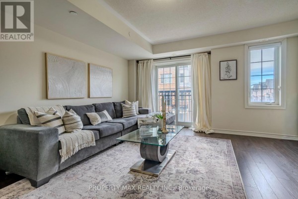 Living room featuring a grey sectional sofa, glass coffee table, and balcony access - 2589 Bromus Path, Oshawa