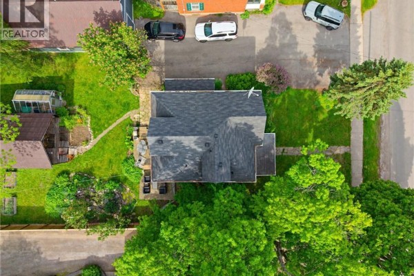 Aerial view of a house with a dark roof, surrounded by green trees and lawn. - 2589 W Jerseyville Road W, Jerseyville