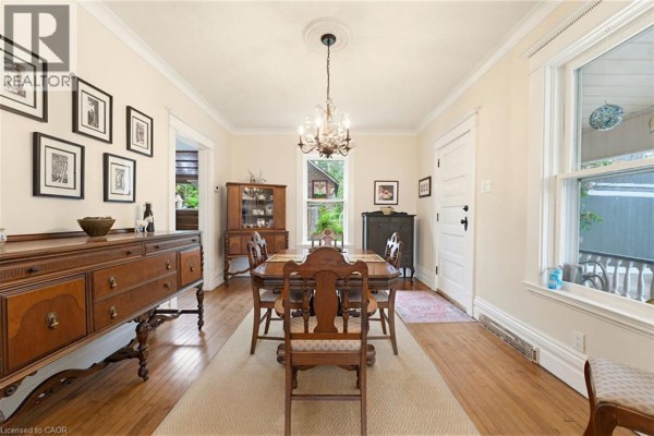 Dining room with a wooden table, chairs, buffet, and crystal chandelier. - 2589 W Jerseyville Road W, Jerseyville