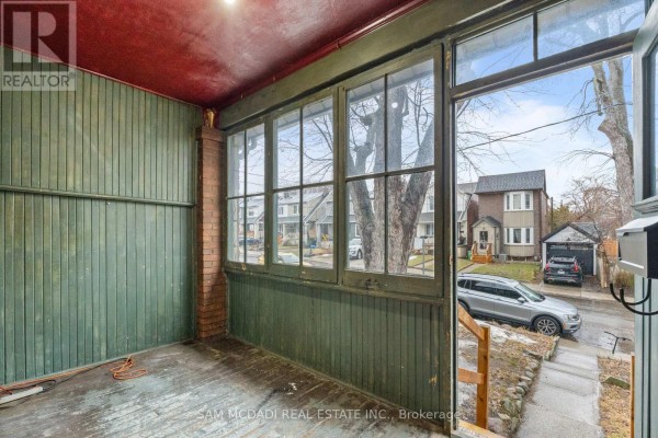 Screened-in porch with green walls and windows, overlooking the front yard. - 259 Milverton Boulevard, Toronto