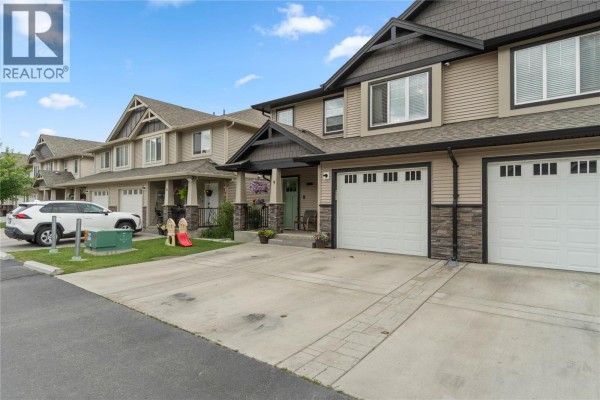 Exterior view of the duplex with two garage doors and stone accents. - 2592 Crestline Street Unit# 9, Kamloops