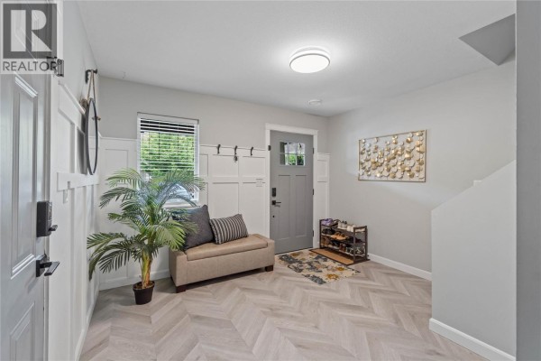 Front entrance of unit 9 with a green door, two chairs, and stone pillars. - 2592 Crestline Street Unit# 9, Kamloops