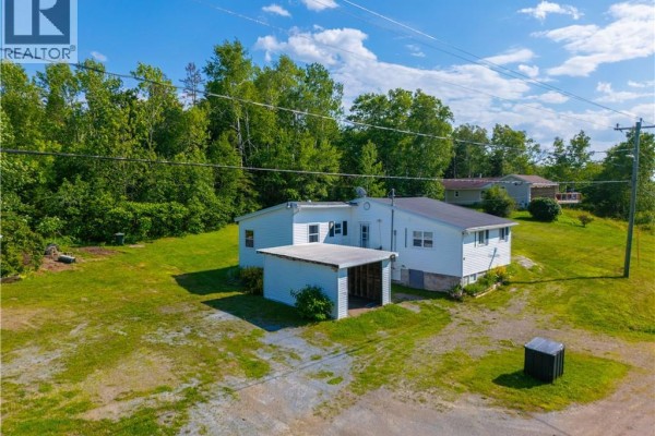 Side exterior view of the white vinyl-sided house and the grassy yard. - 2594 Route 845, Carters Point