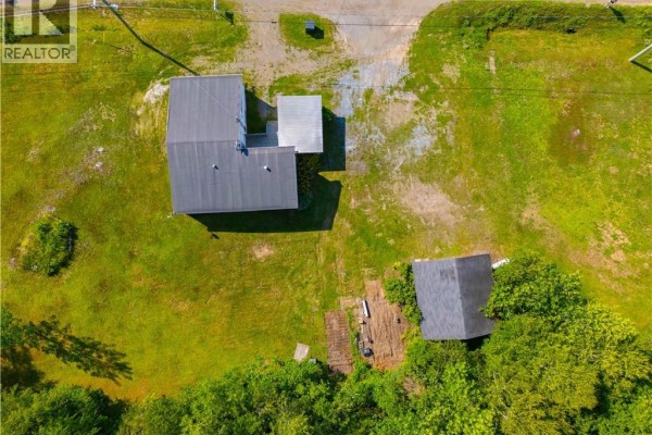 Exterior view of the house and yard, with a detached garage in the background. - 2594 Route 845, Carters Point