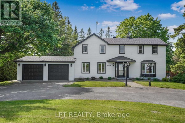 Front view of a white house with black trim and a dark entryway. - 2598 Highway 34 Road, Hawkesbury