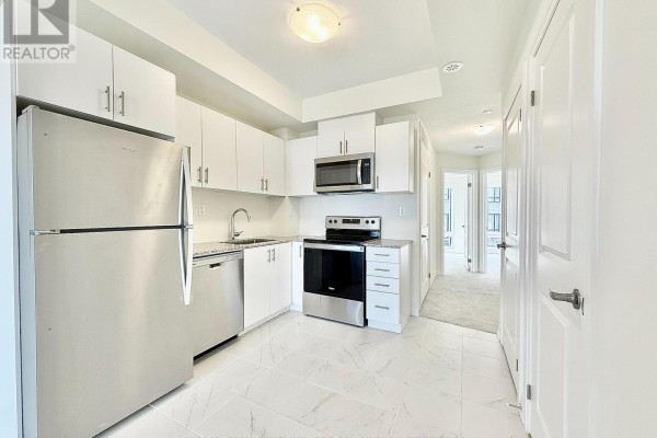 Kitchen with white cabinets, stainless steel appliances, and tile flooring. - 26 - 10 Liben Way, Toronto