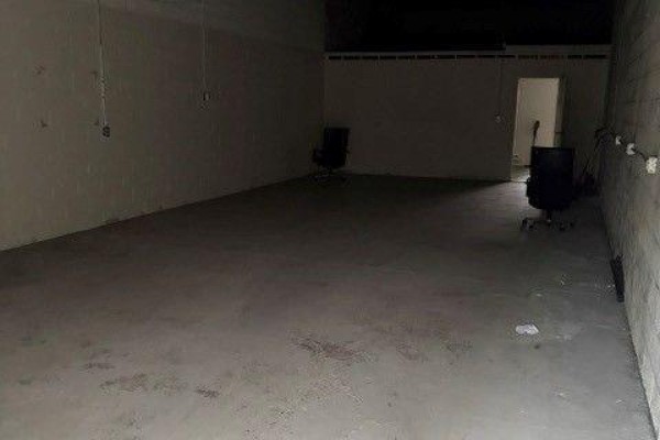 Empty commercial interior space with concrete floors, beige walls, and two black office chairs. - 26 - 4 Vata Court, Aurora