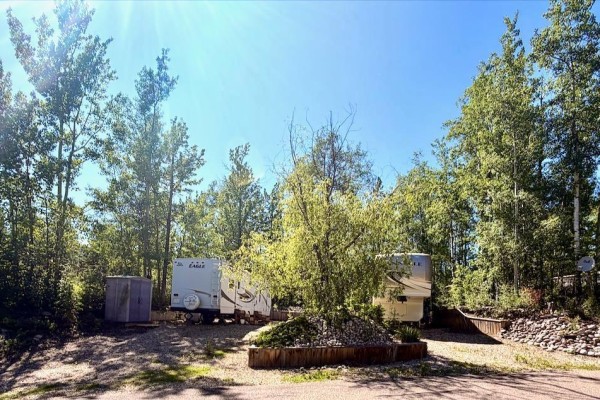 Two RVs parked on gravel lots, surrounded by trees and a Gazebo in the background. - 26 & 27 53213 Hghway 31, Rural Parkland County
