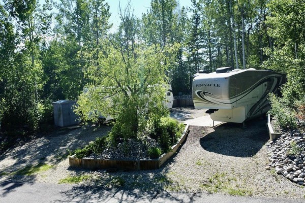 View of wooden stairs leading to RVs with concrete pads and decorative landscaping. - 26 & 27 53213 Hghway 31, Rural Parkland County