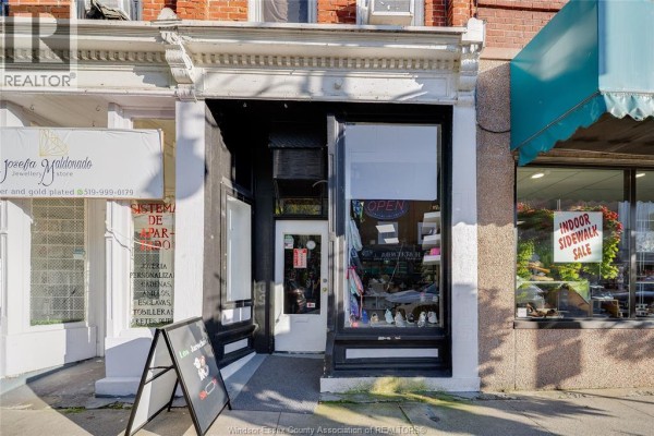 Street view of multiple storefronts with parked cars and trees. - 26-30 Talbot Street East, Leamington