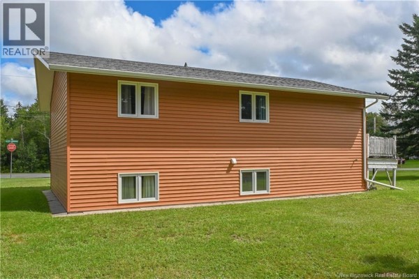 Kitchen counter with white cabinets, stainless steel sink, and a white stove. - 26 Des Patriotes Street, Caraquet