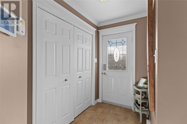 Entrance hall with white double doors, a glass-paned front door, and beige walls. - 26 Hamlet Street, St  John S