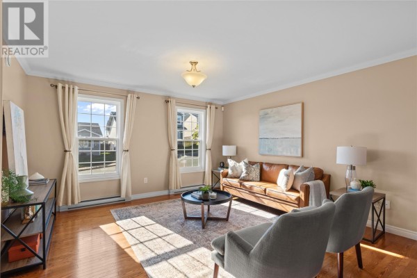 Living room with hardwood floors, a brown leather sofa, two grey chairs, and large windows. - 26 Hamlet Street, St  John S