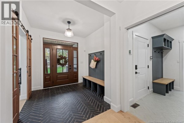 Spacious entryway with dark herringbone tile floor and wood barn doors. - 26 Maefield Street, Lower Coverdale
