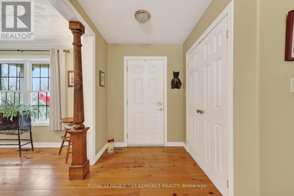 Interior entryway with light pine flooring, a wooden column, and a white double door. - 26 Paddy Dunn's Circle, Springwater