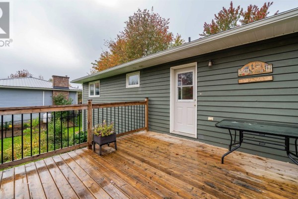 Side view of a grey house with a wooden deck and a white back door. - 26 Poplar Drive, Lantz