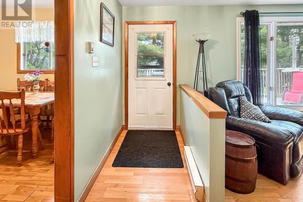 Interior hallway with light green walls, wooden floors, and a view into the dining area. - 26 South Hill Drive, Abercrombie