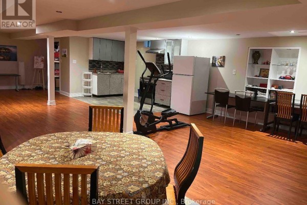 Spacious basement area with dining table, exercise equipment, and a kitchenette. - 26 Stave (lower) Crescent, Richmond Hill