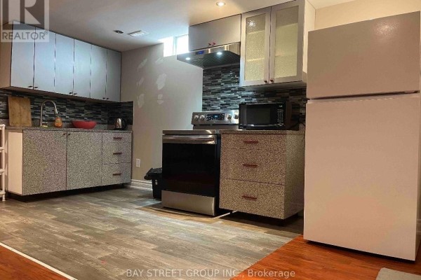 Compact basement kitchenette with speckled cabinets, stainless steel appliances, and tile backsplash. - 26 Stave (lower) Crescent, Richmond Hill