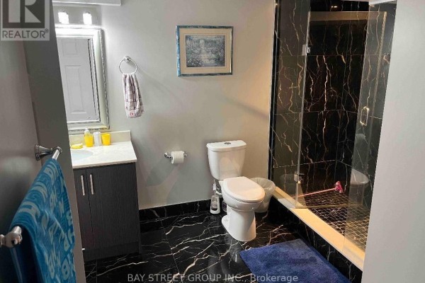 Modern basement bathroom with black marble tile, glass shower enclosure, and vanity. - 26 Stave (lower) Crescent, Richmond Hill