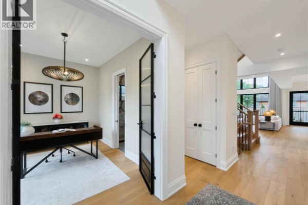View of a home office with a wooden desk and decorative light fixture. - 260 Kent Crescent, Burlington