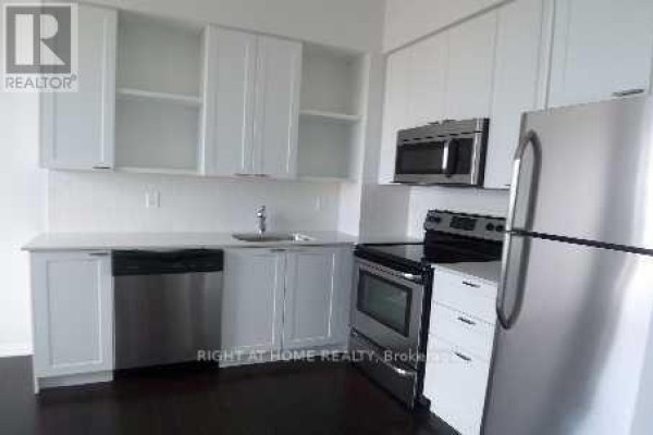 Modern kitchen with white cabinetry, stainless steel appliances, and dark hardwood flooring. - 2601 - 35 Hayden Street, Toronto