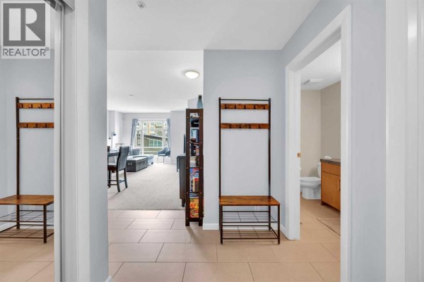 Entryway featuring a laundry area, mirror, and wall hooks. - 2603, 210 15 Avenue Se, Calgary