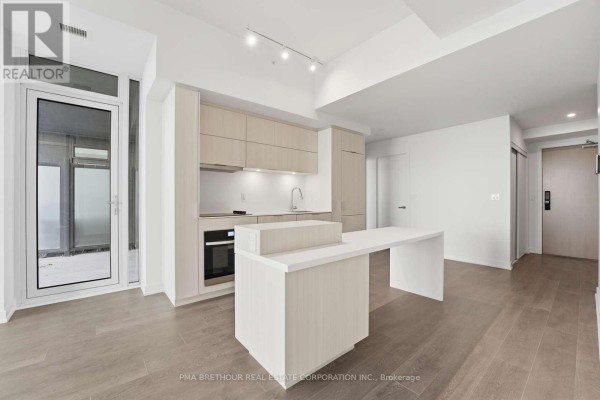 Contemporary kitchen with light wood cabinets, integrated appliances, and a white waterfall island. - 2603 - 370 Martha Street, Burlington