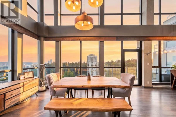 Modern U-shaped kitchen with stainless steel appliances and a breakfast bar with stools. - 2603 271 Francis Way, New Westminster