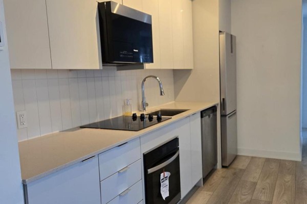 Corner of a room with grey laminate flooring and a large window overlooking a city skyline. - 2604 - 2920 Highway 7, Vaughan