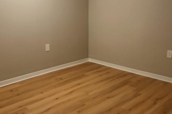 Unfurnished room with beige walls and light wood laminate flooring and white baseboards. - 2605 Innisfil Road, Mississauga