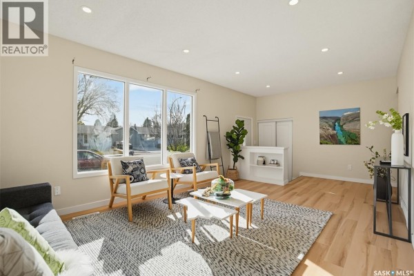 Interior entryway with a glass door, wood cabinets, floral wallpaper, and a chandelier. - 2606 37th Street W, Saskatoon