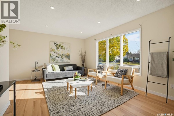 Living room with a large window, red velvet draped curtains, and grey carpet. - 2606 37th Street W, Saskatoon