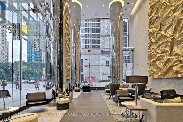 Modern lobby with high ceilings, glass walls, polished columns, and seating areas. - 2607 - 10 York Street, Toronto