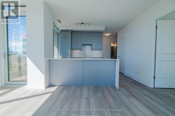 Modern kitchen with light blue cabinets, white countertops, and a large island with a sink. - 2607 - 36 Elm Drive W, Mississauga