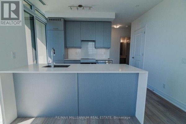 Open concept living area with light wood floors, white walls, and a view of the city skyline. - 2607 - 36 Elm Drive W, Mississauga