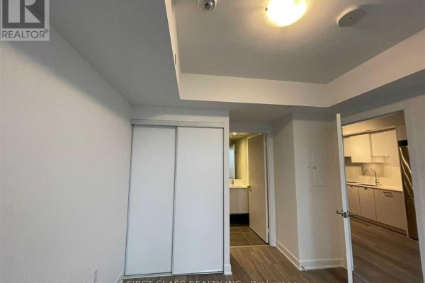 View of the living area, kitchen, and a partially open bathroom door with vanity. - 2608 - 195 Redpath Avenue, Toronto