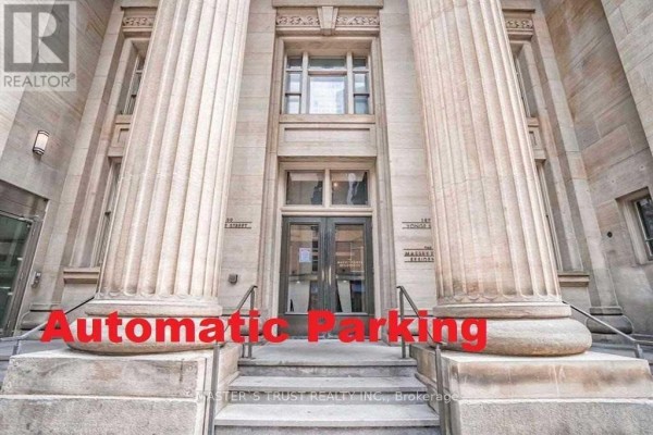 Entrance to a building with large stone columns and glass doors. - 2609 - 197 Yonge Street, Toronto