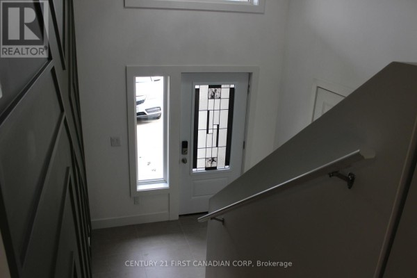 Another angle of the entryway highlighting the front door and staircase. - 2609 Oil Heritage Road, Oil Springs